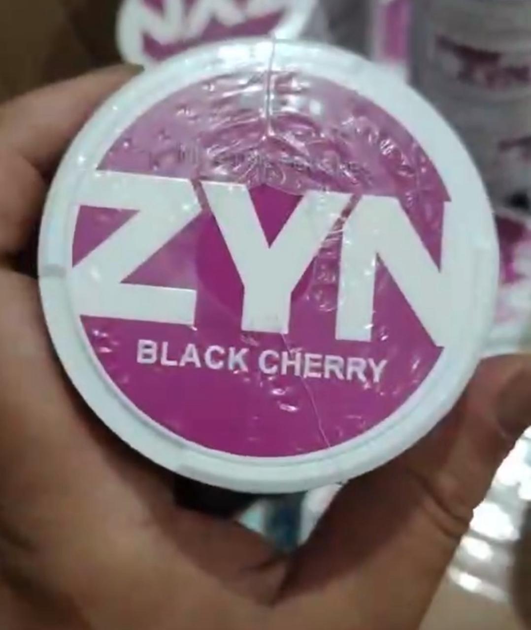 Container of ZYN Nicotine Pouches Black Cherry flavor on a hand