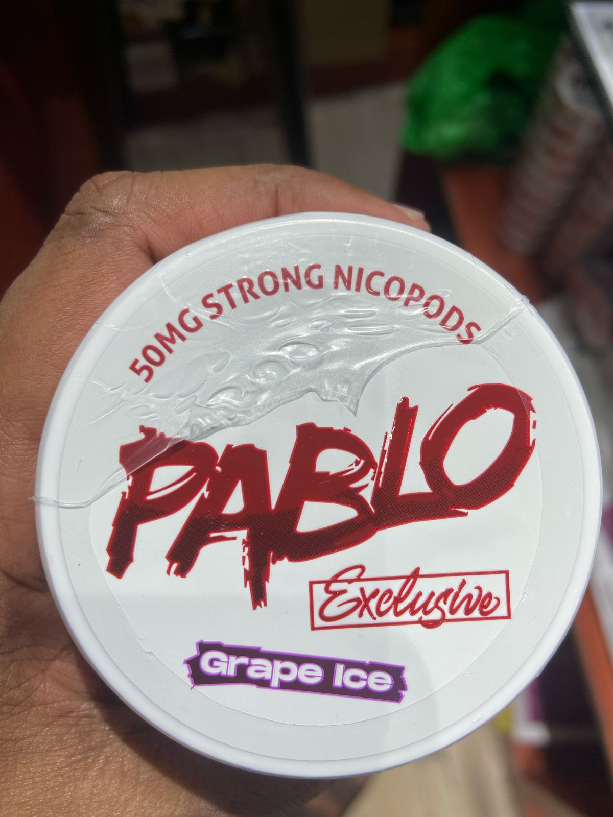 Pablo Nicotine Pouches Grape Ice flavor 50mg Strong Nicopods Container held by a hand