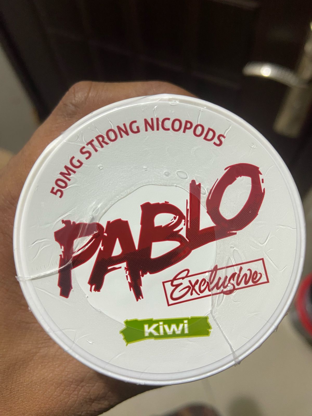 Pablo Nicotine Pouches Kiwi flavor 50mg Strong Nicopods Container held by a hand